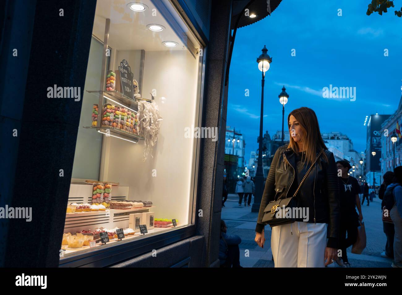 Vetrine di una donna presso il punto di riferimento pastelería la Mallorquina a Puerta del Sol, Madrid, Spagna. Foto Stock