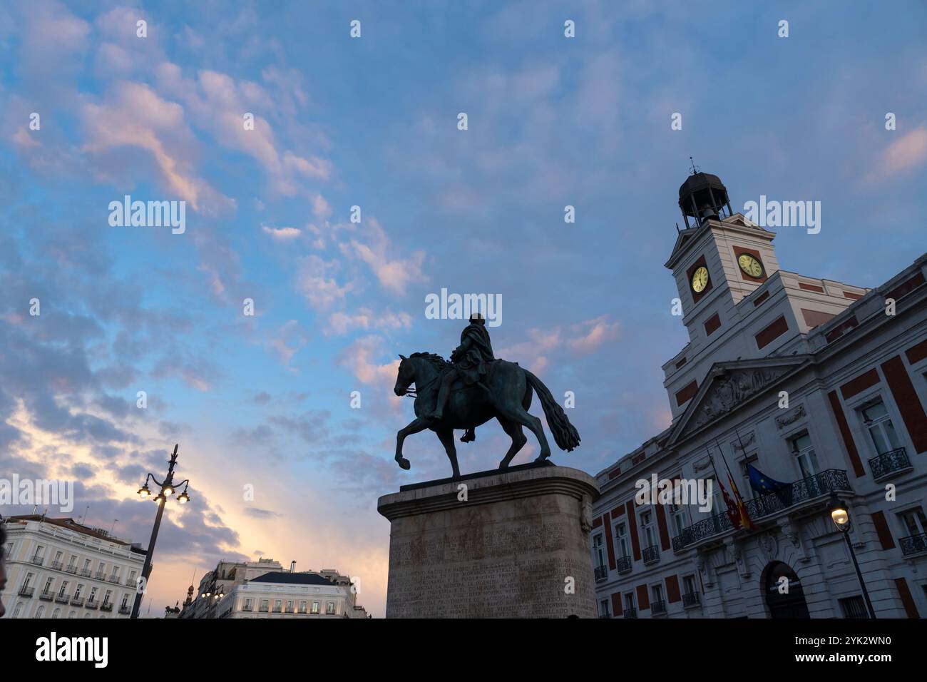 Il sole tramonta sulla statua equestre di Carlo III di Spagna nella Puerta del Sol a Madrid, Spagna. Foto Stock