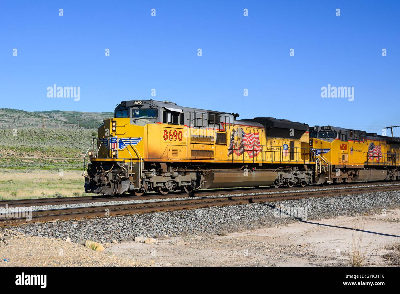 Helper, UT, USA - 11 giugno 2024; treno merci Union Pacific che attraversa l'alto paesaggio desertico dello Utah Foto Stock