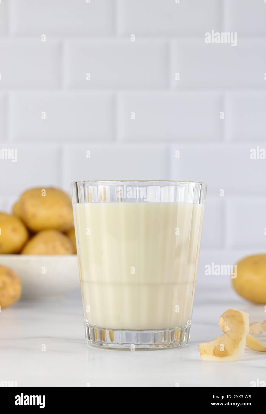 Latte di patate vegane e patate su sfondo bianco. Latte vegetale privo di lattosio. Latte vegetale. Copia spazio. Foto Stock