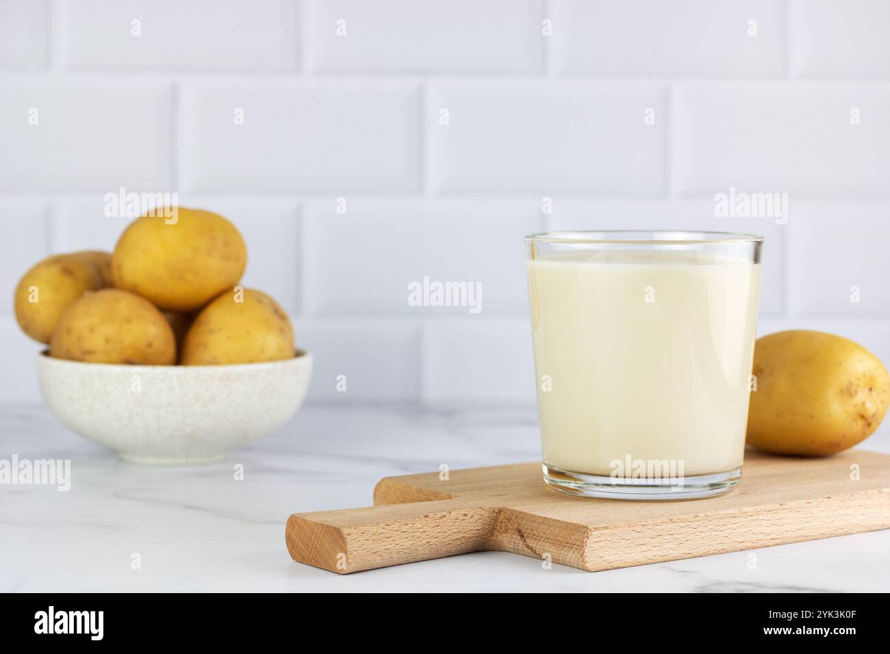 Latte di patate vegane e patate su sfondo bianco. Latte vegetale privo di lattosio. Latte vegetale. Copia spazio. Foto Stock