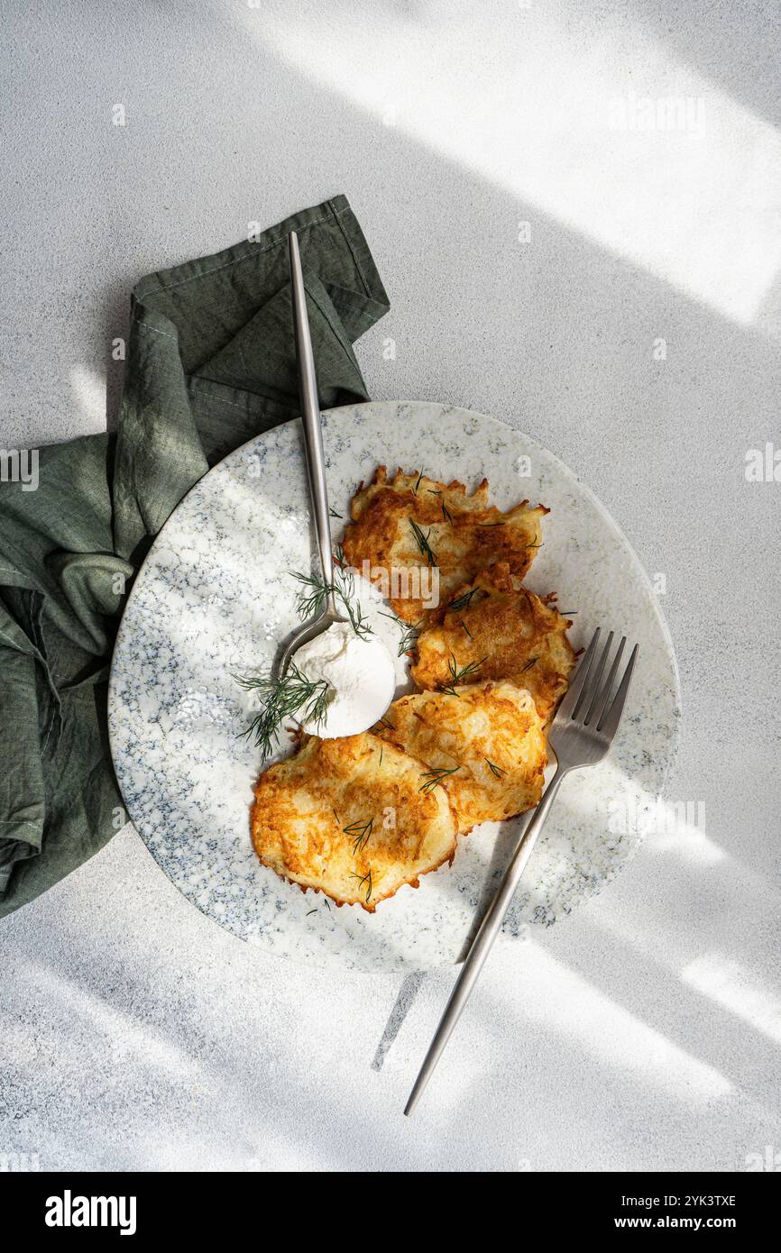 Frittelle di patate con salsa di panna acida e aneto fresco Foto Stock
