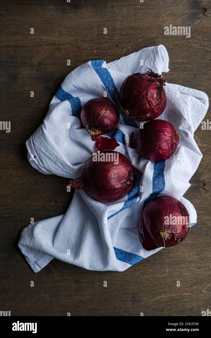 Cipolle rosse intere su un telo rustico Foto Stock