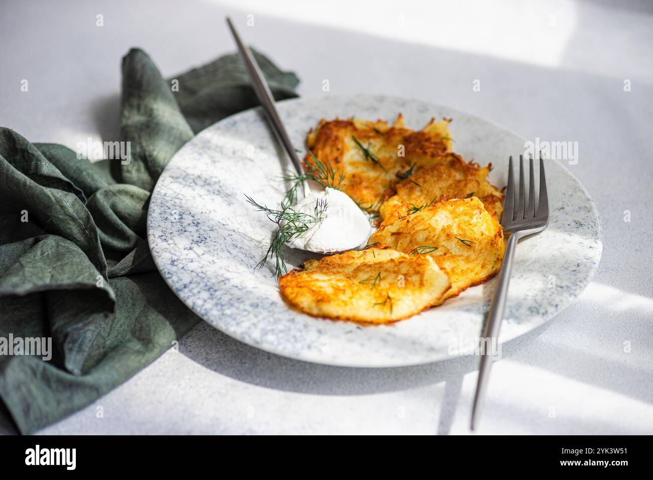 Frittelle di patate con salsa di panna acida e aneto fresco Foto Stock