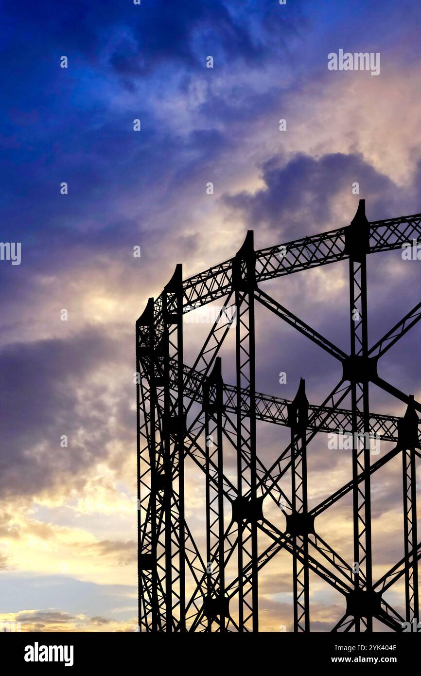 L'iconico Gasometro nel quartiere Ostiense si staglia contro un vibrante cielo al tramonto, Roma, Italia Foto Stock