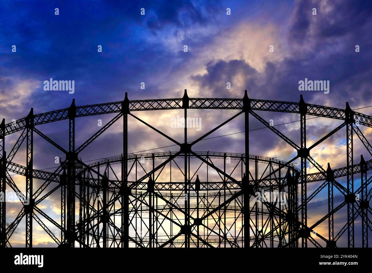 L'iconico Gasometro nel quartiere Ostiense si staglia contro un vibrante cielo al tramonto, Roma, Italia Foto Stock
