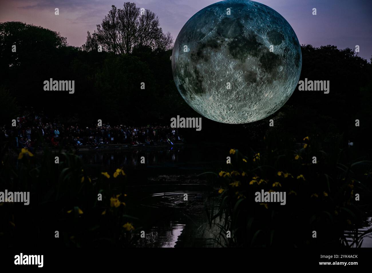 La luna gonfiabile di 7 metri di diametro dell'artista Luke Jerram è sospesa sullo stagno del Queens Park di Brighton durante il Brighton Festival. Il modello lunare illuminato è una delle numerose copie che girano il mondo per la mostra temporanea di Luke. Presenta immagini dettagliate della superficie lunare della NASA, con ogni centimetro della sfera illuminata che rappresenta 5 km della superficie lunare. L'evento di arti libere fa parte del Brighton Festival, che è una celebrazione annuale di arte, musica, teatro, danza, circo, e la letteratura, che si svolge nella città di Brighton e Hove durante il mese di Foto Stock