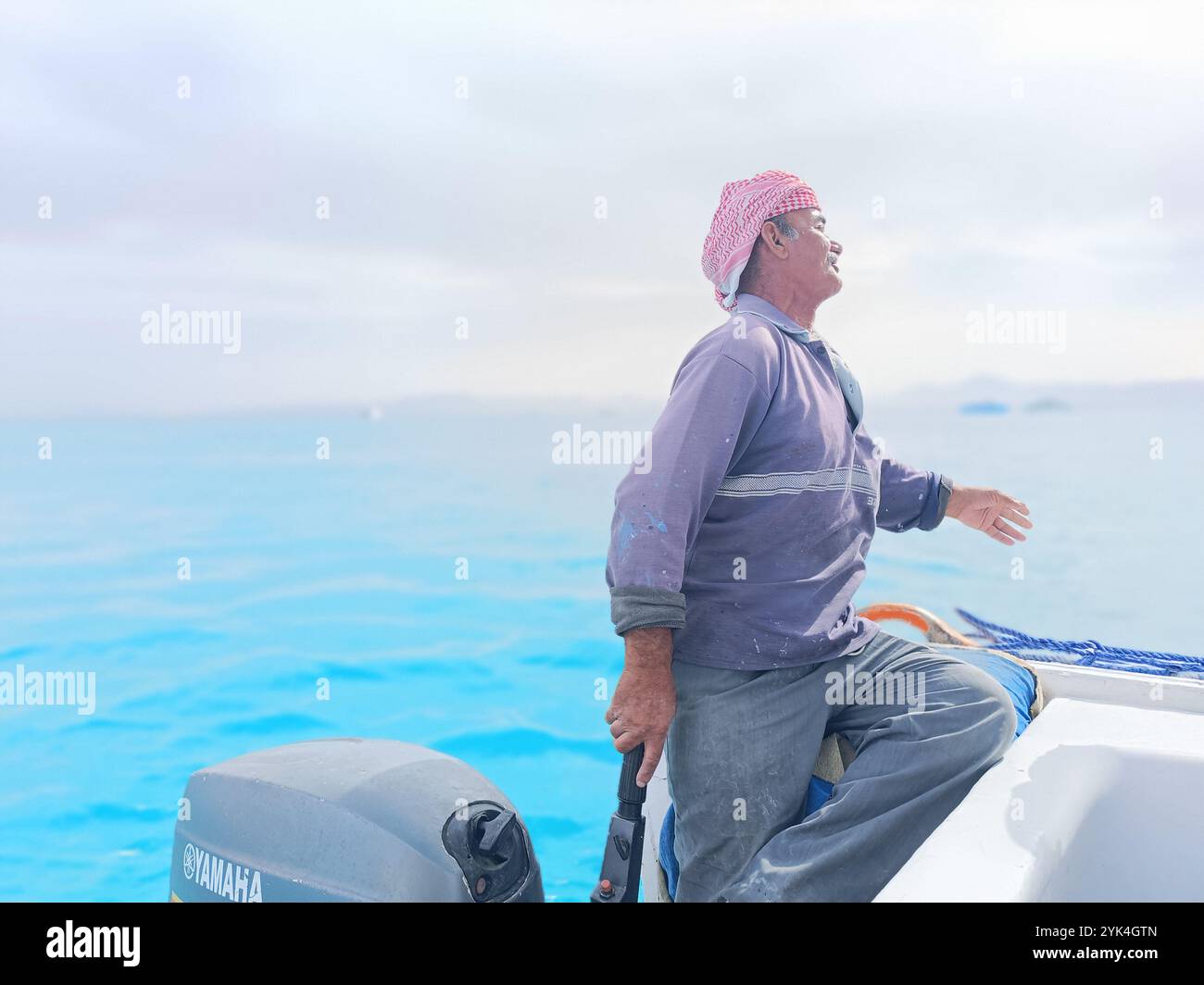 Old Sailor in the Sea Riding and Sailing with HIS Boat un vecchio marinaio con un bianco con baffi bianchi che indossa una sciarpa beduina sulla testa Foto Stock