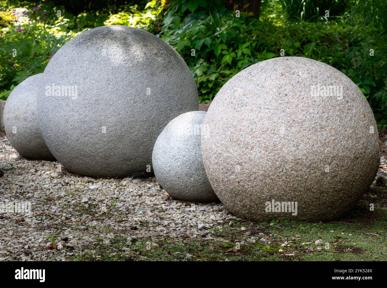 Palle di pietra pesanti in giardino Foto Stock