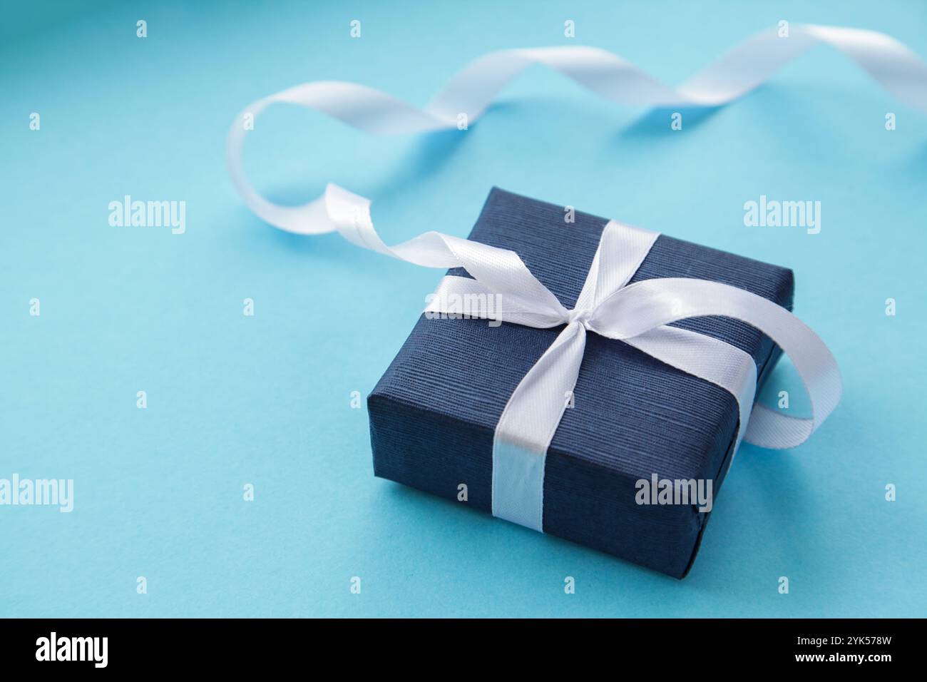 Confezione regalo blu scuro su sfondo azzurro. Regalo per gli uomini. Festa dei padri. Un regalo per lui. Copia spazio Foto Stock