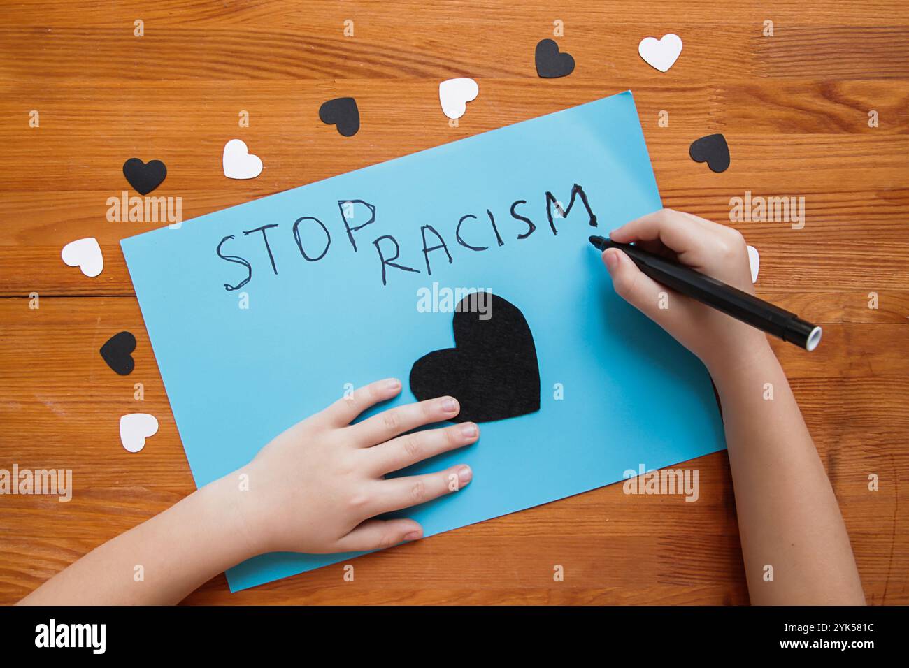 Un bambino caucasico scrive un poster "Stop Racism". Attivismo e movimento per i diritti umani. Fermare il razzismo e il concetto di bambini. Niente razzismo contro i bambini. Razziale Foto Stock