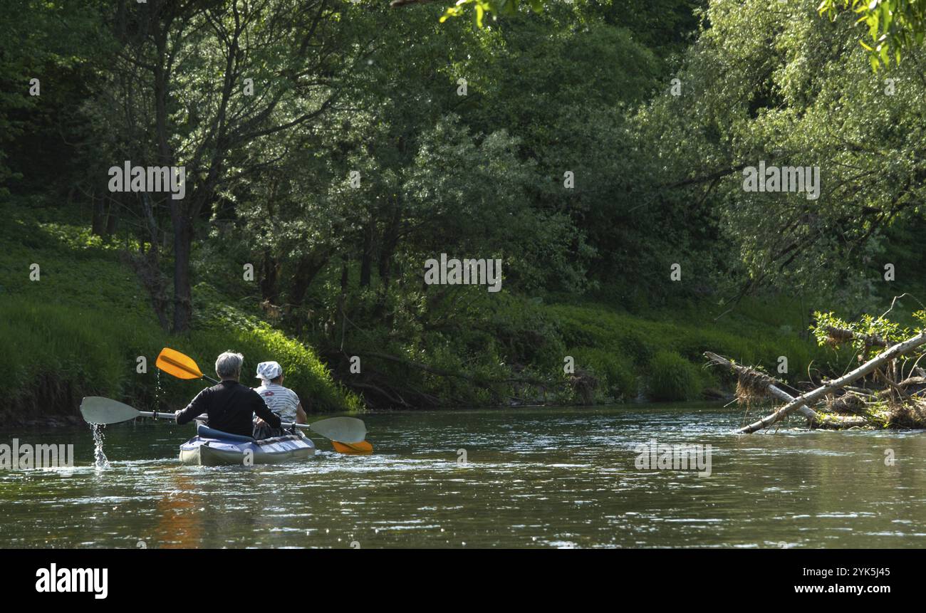 Gita in kayak per tutta la famiglia per il Seigneur e senora. Una coppia di anziani sposati che voga una barca sul fiume, un'escursione in acqua, un'avventura estiva. Sport legati all'età Foto Stock