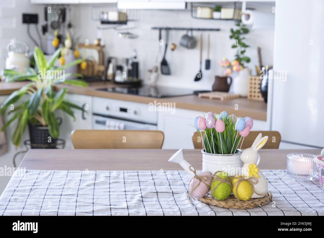 Pasqua decorazione di uova colorate in un cesto e un coniglio sul tavolo da cucina in stile rustico. Interno festoso di una casa di campagna Foto Stock