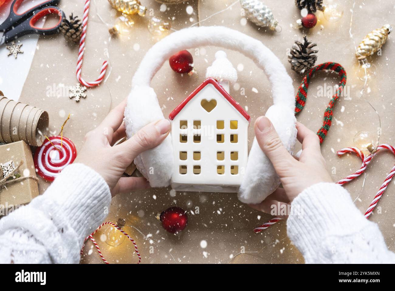 Casa accogliente con arredamento natalizio, calda sciarpa a maglia, cappello, interni invernali. Inverno, neve, isolamento domestico, protezione dalle basse temperature, riscaldamento ambiente Foto Stock