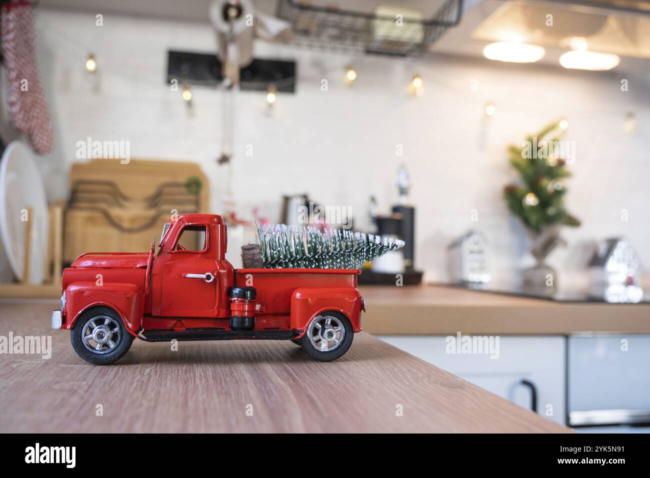 Una macchina rossa retrò con un albero di Natale decora la cucina festosa per Natale. Arredamento per la casa, atmosfera festiva, Capodanno Foto Stock