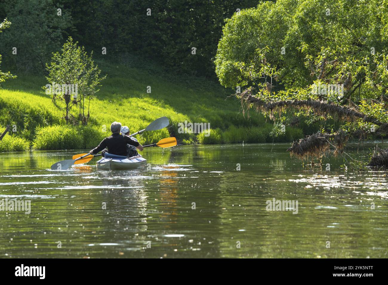 Gita in kayak per tutta la famiglia per il Seigneur e senora. Una coppia di anziani sposati che voga una barca sul fiume, un'escursione in acqua, un'avventura estiva. Sport legati all'età Foto Stock
