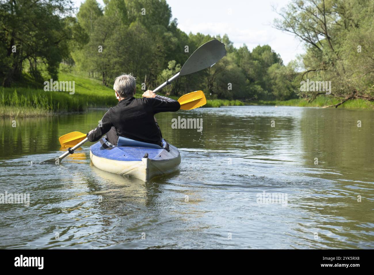 Gita in kayak per tutta la famiglia per il Seigneur e senora. Una coppia di anziani sposati che voga una barca sul fiume, un'escursione in acqua, un'avventura estiva. Sport legati all'età Foto Stock