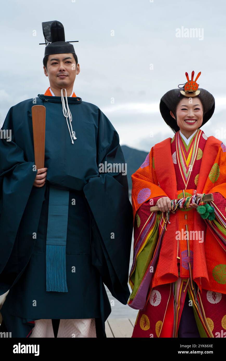 Una coppia di nozze in tradizionale kimono del periodo Heian posa per una foto al Santuario di Itsukushima sull'isola di Miyajima, prefettura di Hiroshima, Giappone. Foto Stock