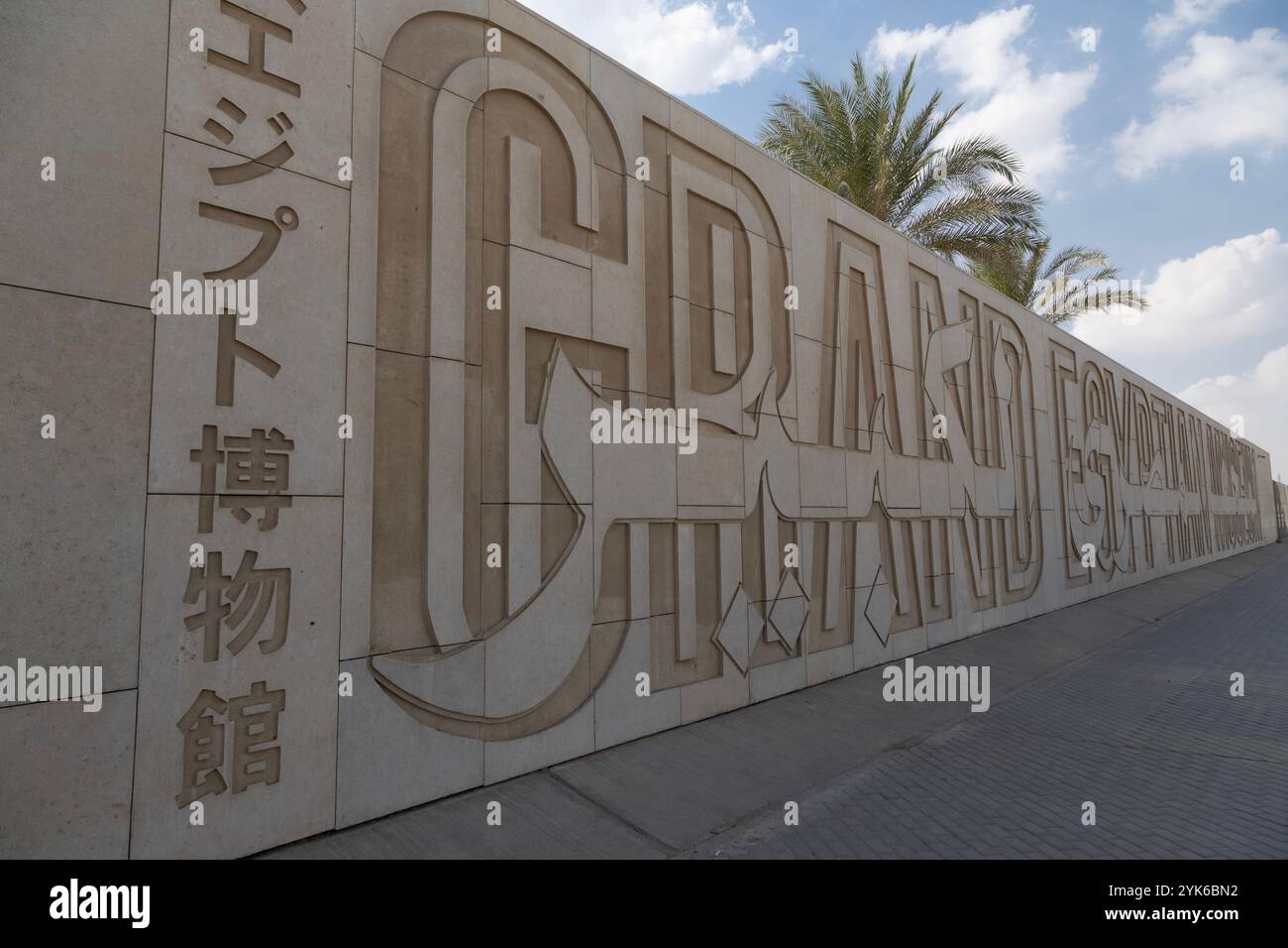 Il nome intelligente, artistico e multilingue del Grand Egyptian Museum, scolpito nel muro che segna il perimetro del complesso appena aperto. Foto Stock