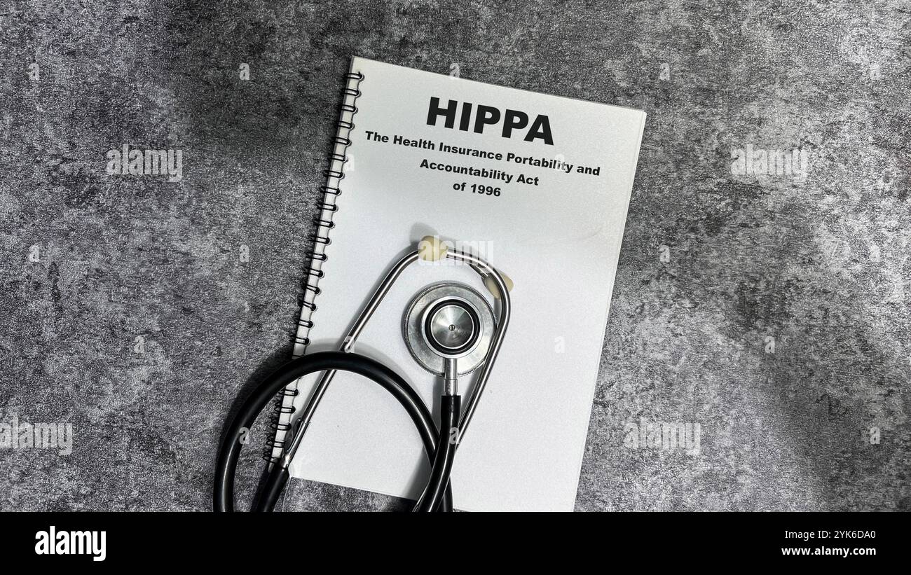 Concetto di HIPPA - il Health Insurance Portability and Accountability Act del 1996 scrivere su libro isolato su tavolo di legno. Foto Stock