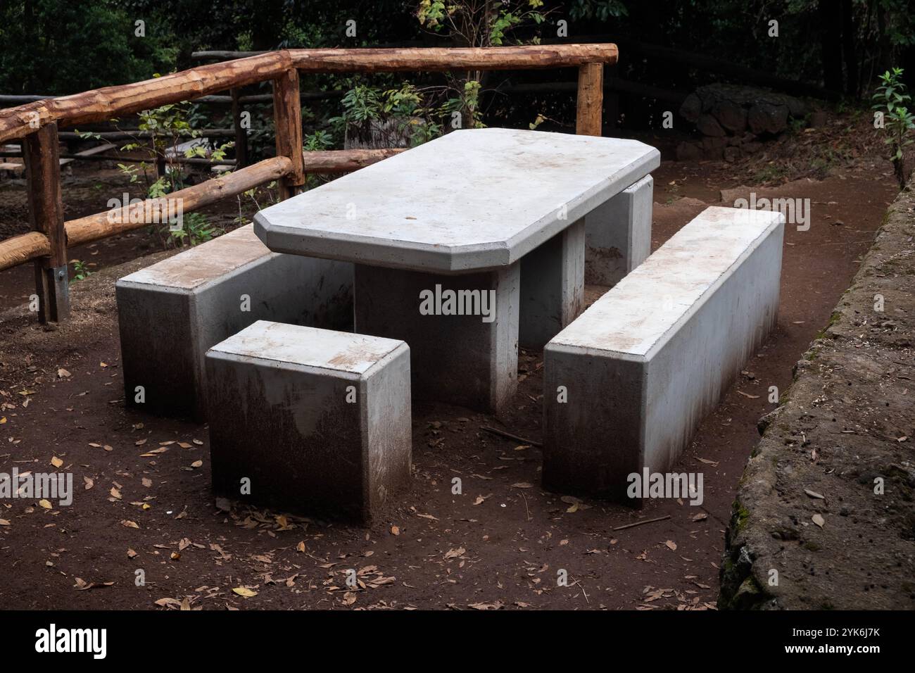 area picnic pubblica nel bosco con tavolo in cemento e panchine vicino al sentiero escursionistico . Foto Stock