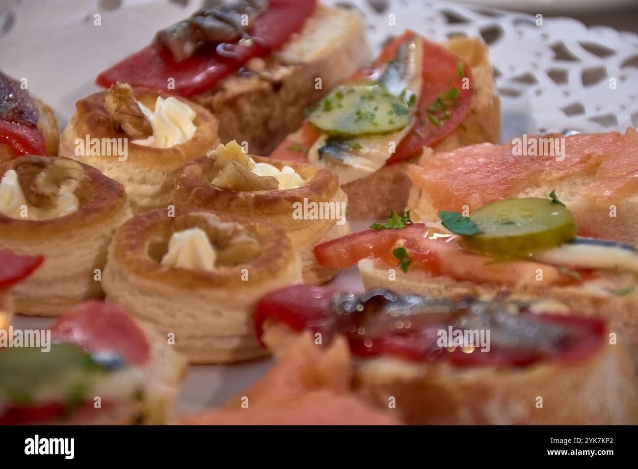 Primo piano di un piatto con stuzzichini assortiti, tra cui tartine e piccoli spuntini, splendidamente organizzato per un evento gourmet o una riunione. Foto Stock