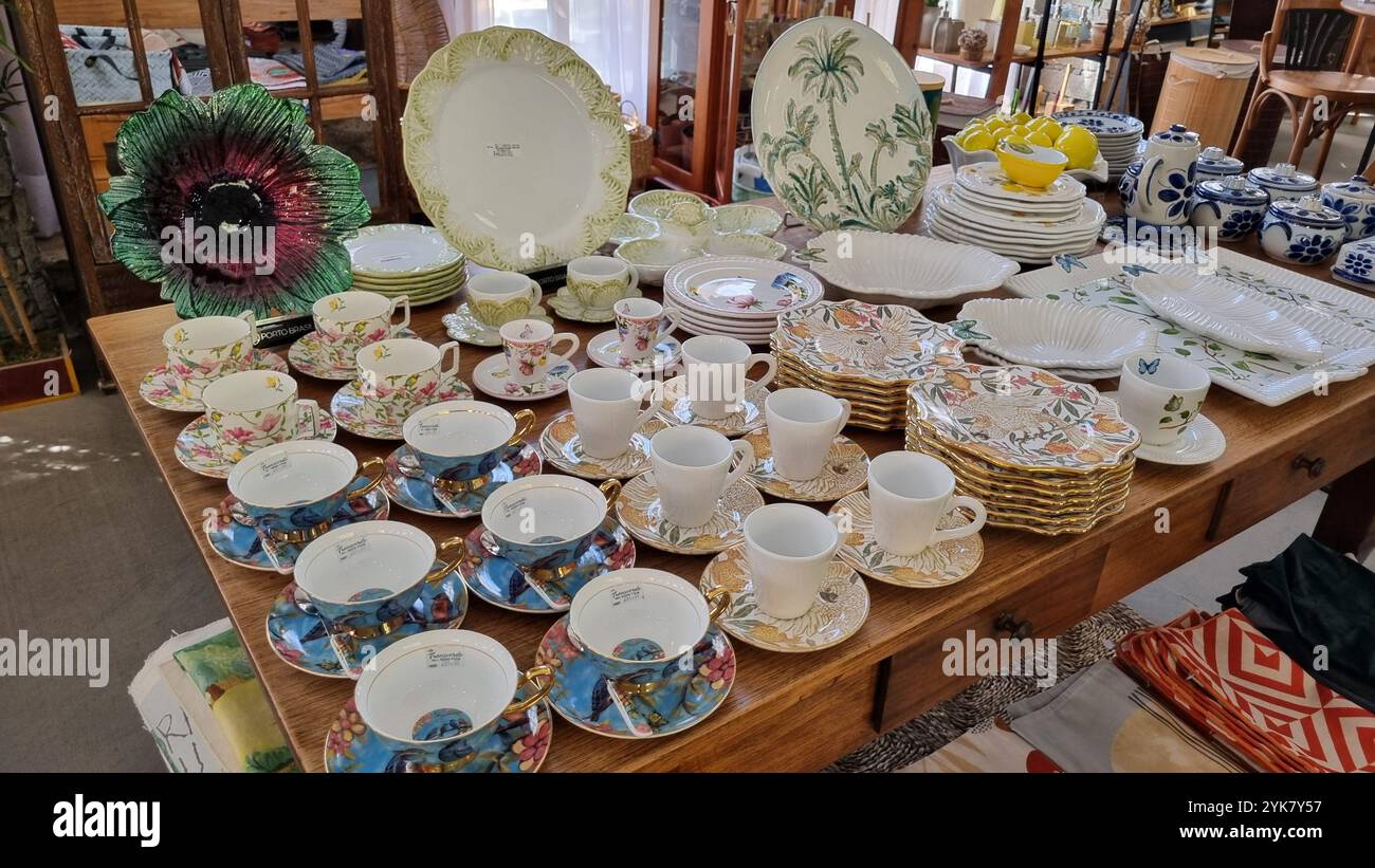 Una splendida collezione di stoviglie e oggetti decorativi vintage esposti su un tavolo in legno - Immagine stock catturata con smartphone