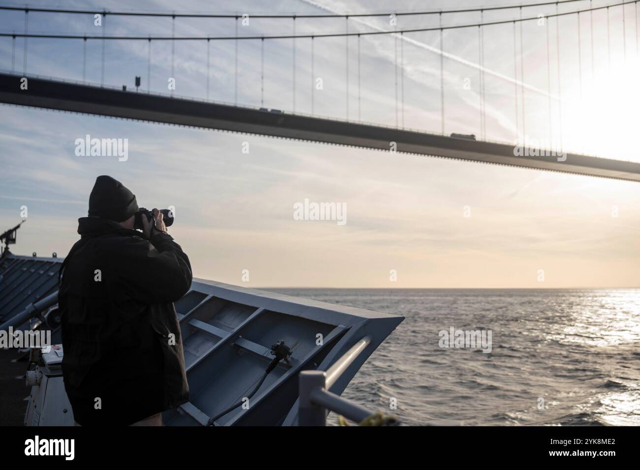 DANISH STRAITS (30 ottobre 2024), Senior Chief Logistics Specialist Brent Shannon, nativo di Columbus, New Jersey, scatta foto del Great Belt Bridge mentre l'incrociatore missilistico guidato classe Ticonderoga USS Gettysburg (CG 64) transita nello stretto danese, ottobre 30. La USS Gettysburg, assegnata all'Harry S. Truman Carrier Strike Group (HSTCSG), è in uno spiegamento programmato nella sesta area di operazioni della flotta statunitense a supporto delle forze navali USA Europa-Africa per difendere gli interessi degli Stati Uniti, alleati e partner. (Foto della Marina degli Stati Uniti di Kaitlin Young, specialista della comunicazione di massa di seconda classe) Foto Stock
