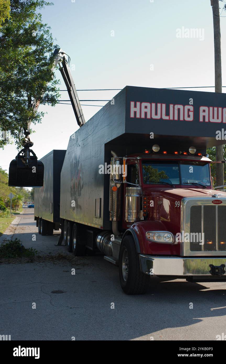 Solo per uso editoriale 16 novembre 2024. St. Petersburg, Florida, Stati Uniti. Gru per il trasporto di rifiuti raccolta di danni causati da tempeste da un autocarro specializzato dotato di gru, Foto Stock