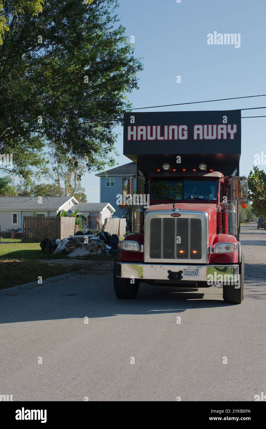 Solo per uso editoriale 16 novembre 2024. St. Petersburg, Florida, Stati Uniti. Gru per il trasporto di rifiuti raccolta di danni causati da tempeste da un autocarro specializzato dotato di gru, Foto Stock