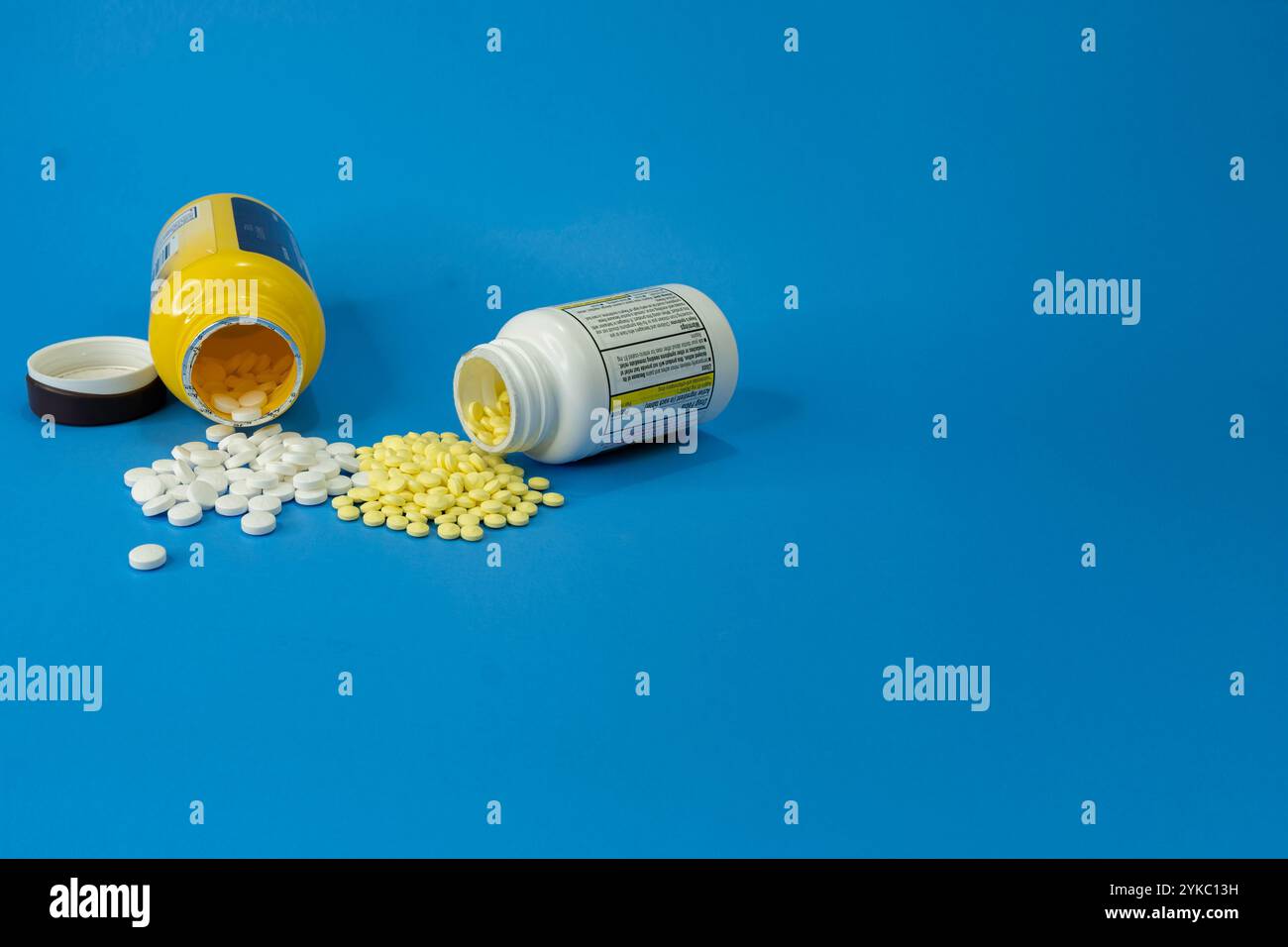 Sia l'aspirina normale che quella Baby sono fuoriuscite su sfondo blu. Foto Stock