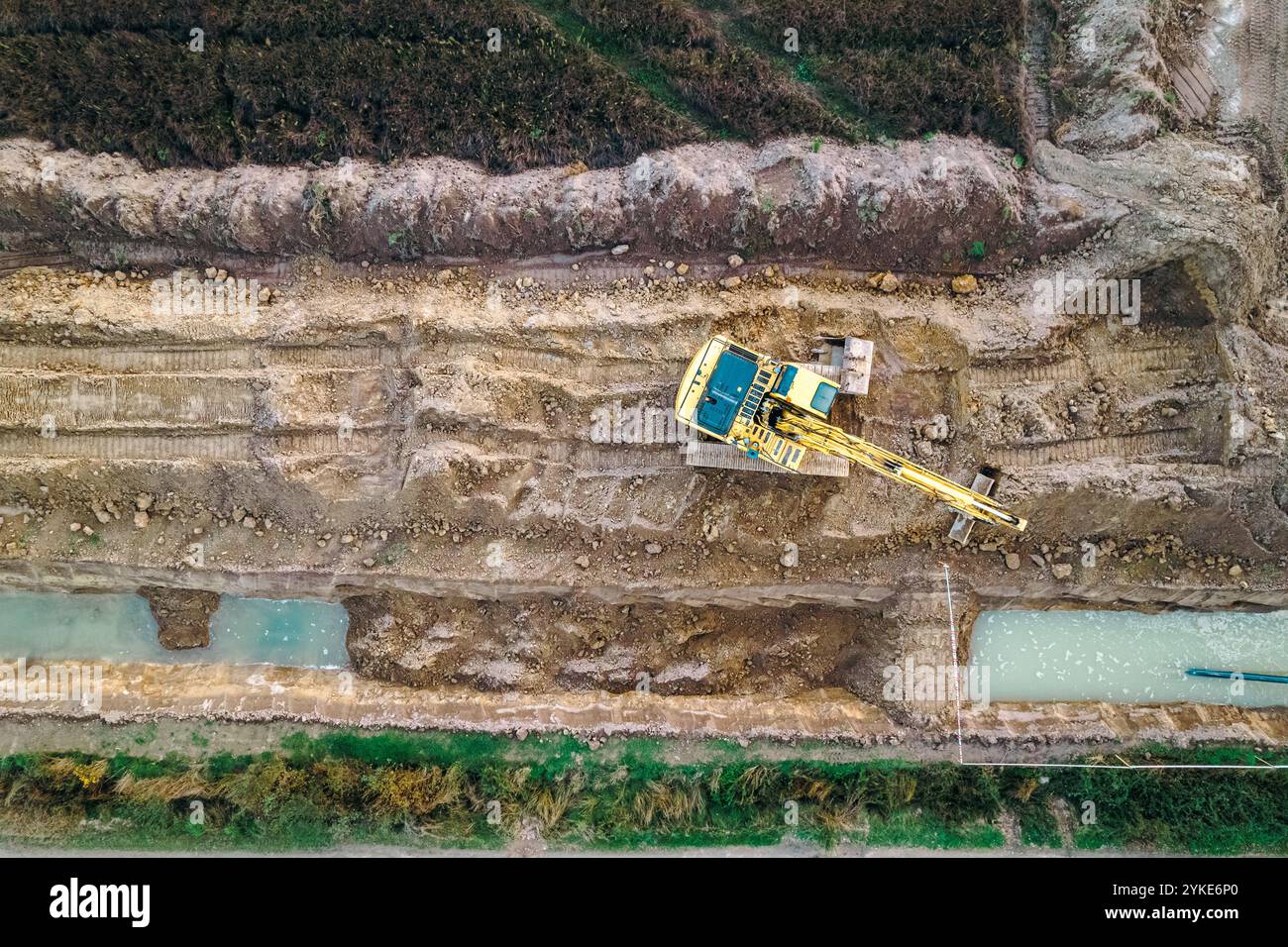 vista dall'alto del drone, immagine aerea di un escavatore terrestre che scavava una trincea in un cantiere edile, sfondo del concetto di costruzione Foto Stock