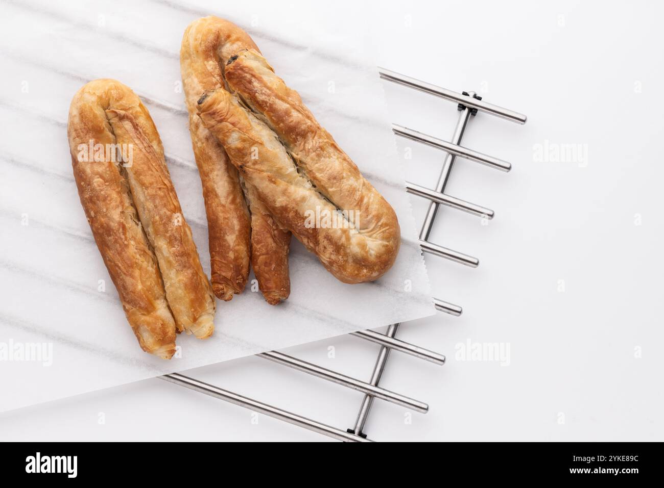 Cibo appena sfornato, dolci salati su Metal rack, torta al formaggio greco o banitsa al burro bulgaro per colazione Foto Stock