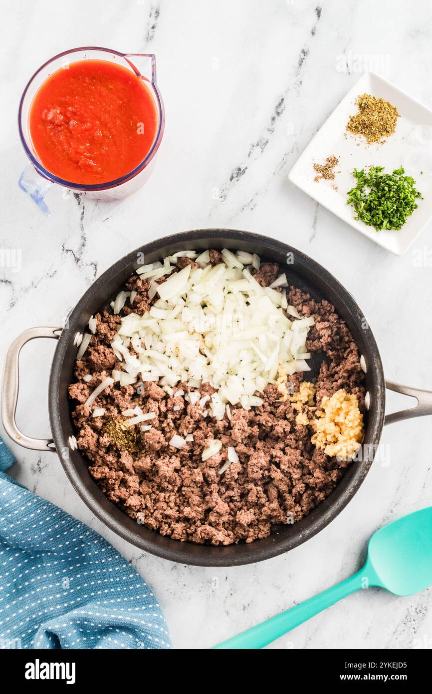 Carne macinata e cipolle in una padella con spezie e aglio Foto Stock