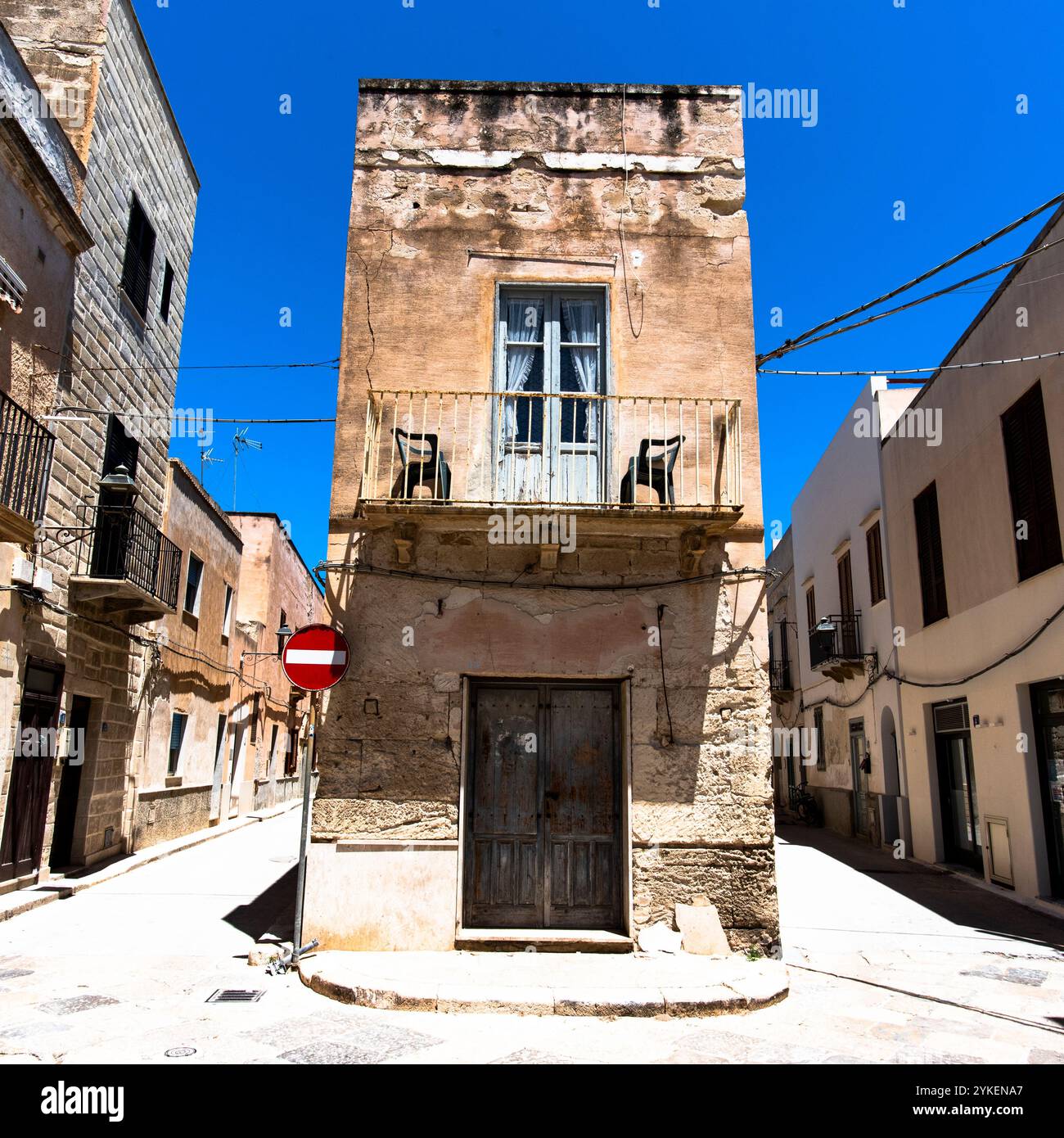 inusuale casa architettonica all'incrocio con geometrie e simmetrie casuali e inaspettate di colore giallo della pietra di tufo con cui è costruita Foto Stock