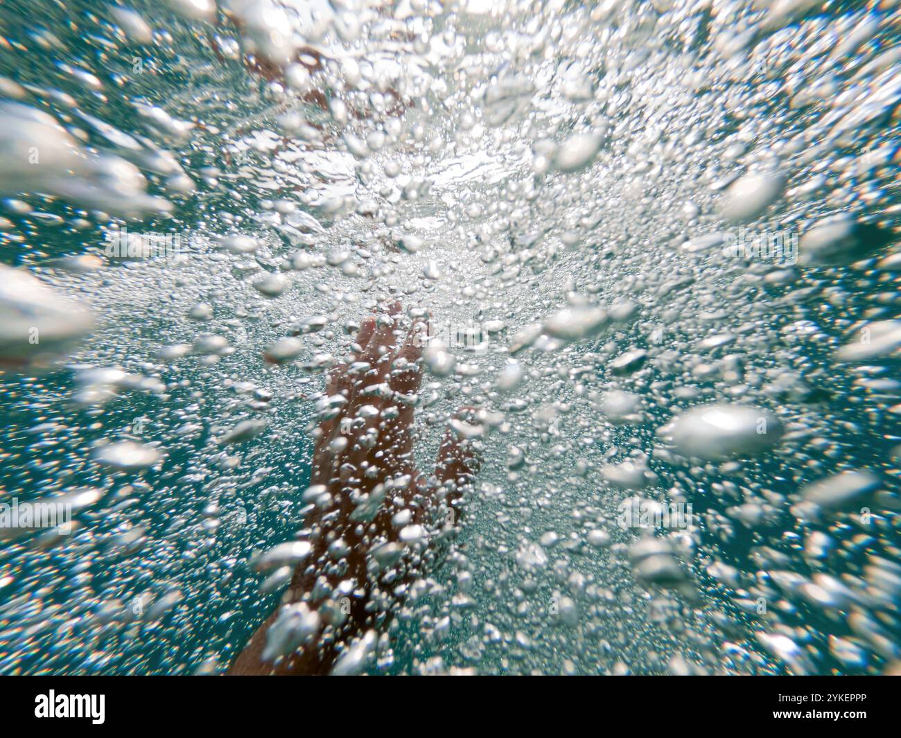 Annegamento che solleva la mano attraverso le acque profonde dell'oceano per chiedere aiuto e assistenza, riprese subacquee, messa a fuoco selettiva Foto Stock