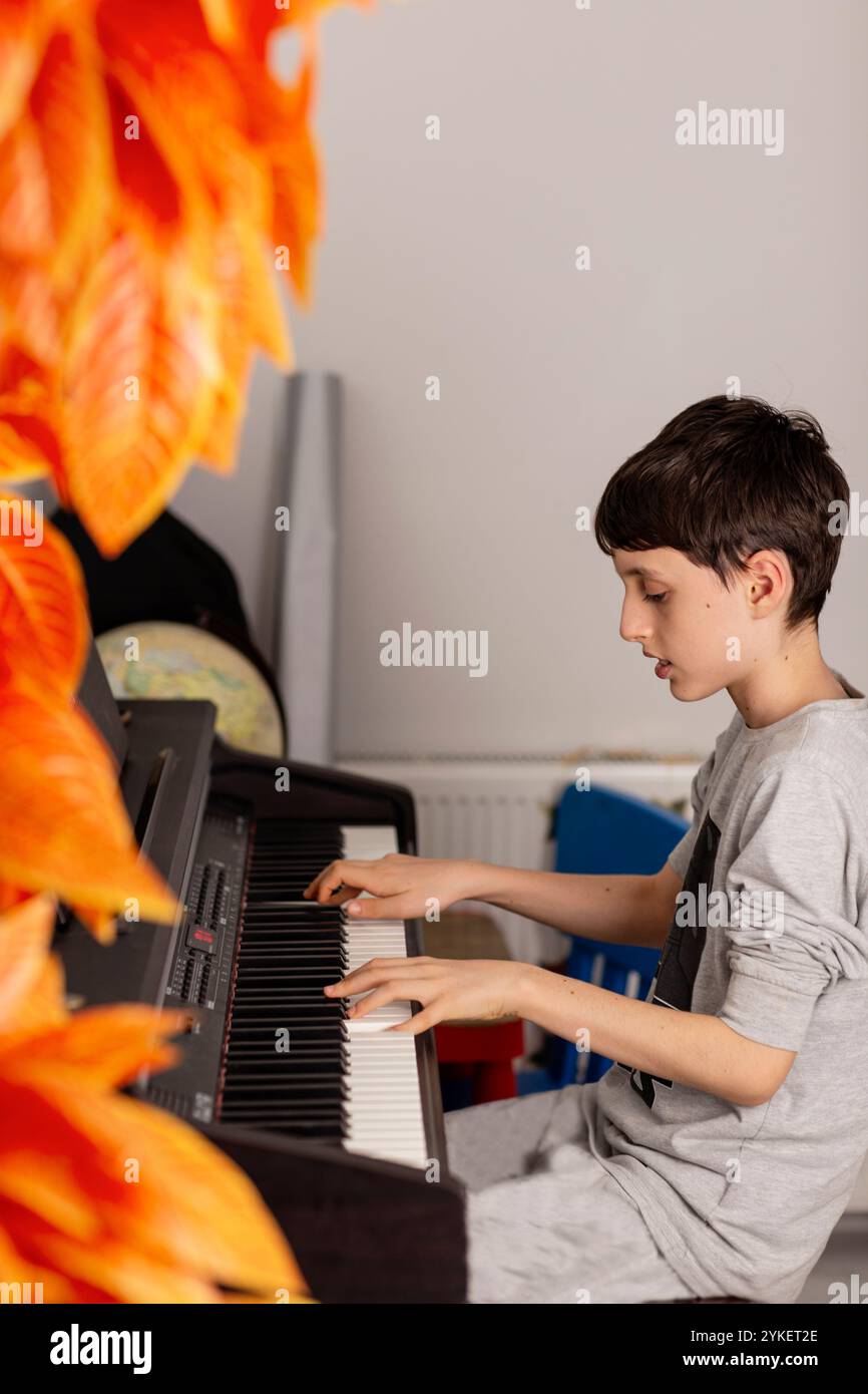 Accogliente vista sul ragazzo che suona il pianoforte a casa Foto Stock