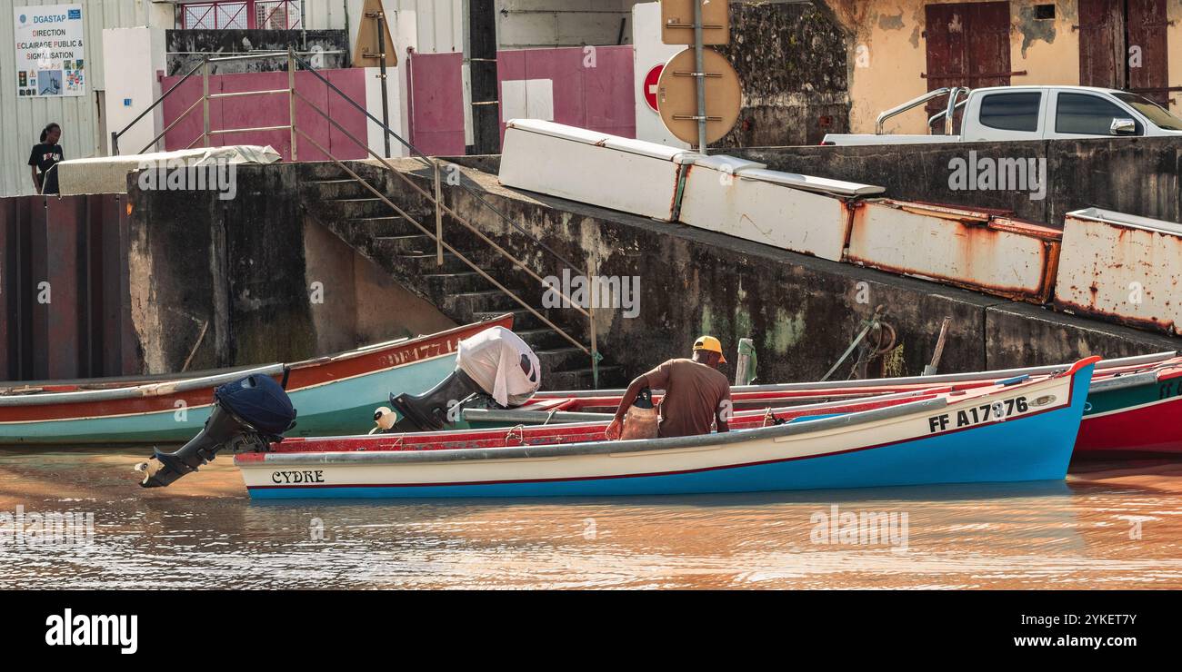 Fort-de-France, Martinica - 3 gennaio 2018: I pescatori preparano le loro barche per il lavoro di una giornata in un molo sul lungomare. Foto Stock