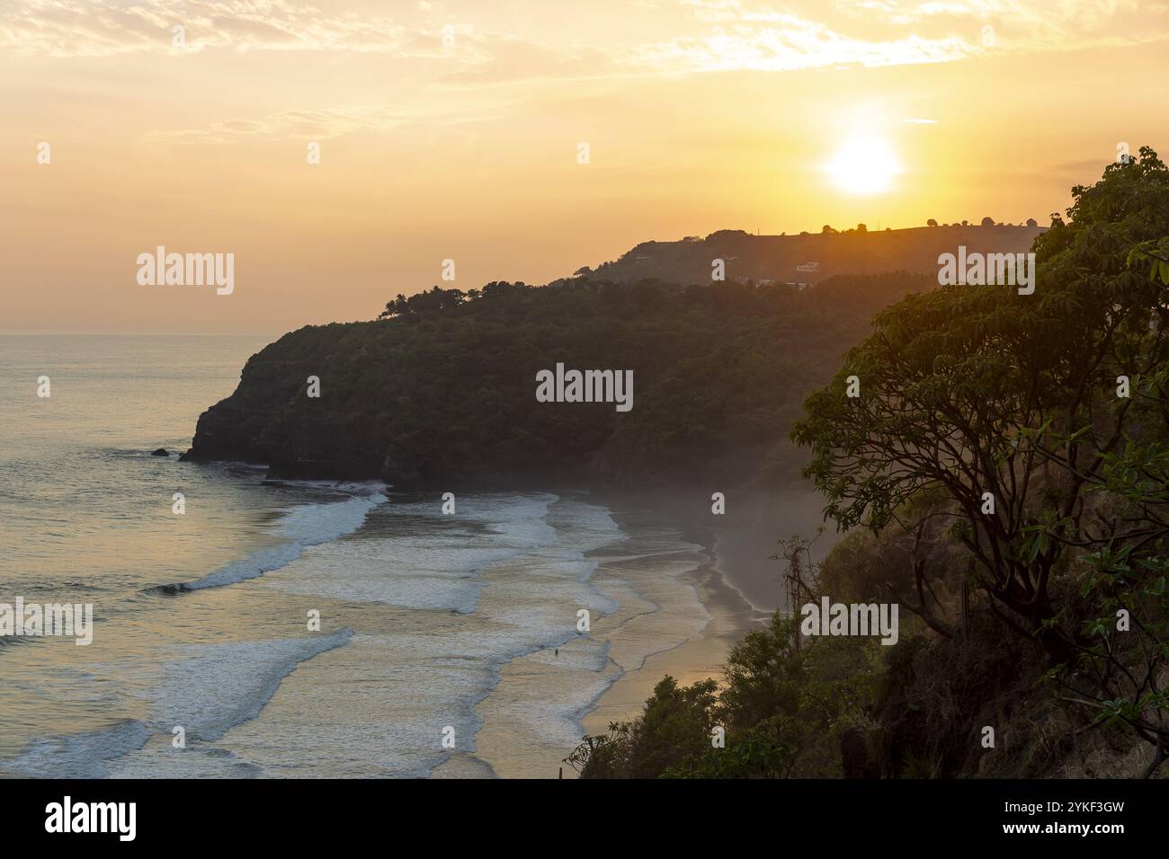 Una vista mozzafiato del tramonto sull'Oceano Pacifico a Mizata Beach, El Salvador, che mette in risalto la costa e la vegetazione lussureggiante Foto Stock