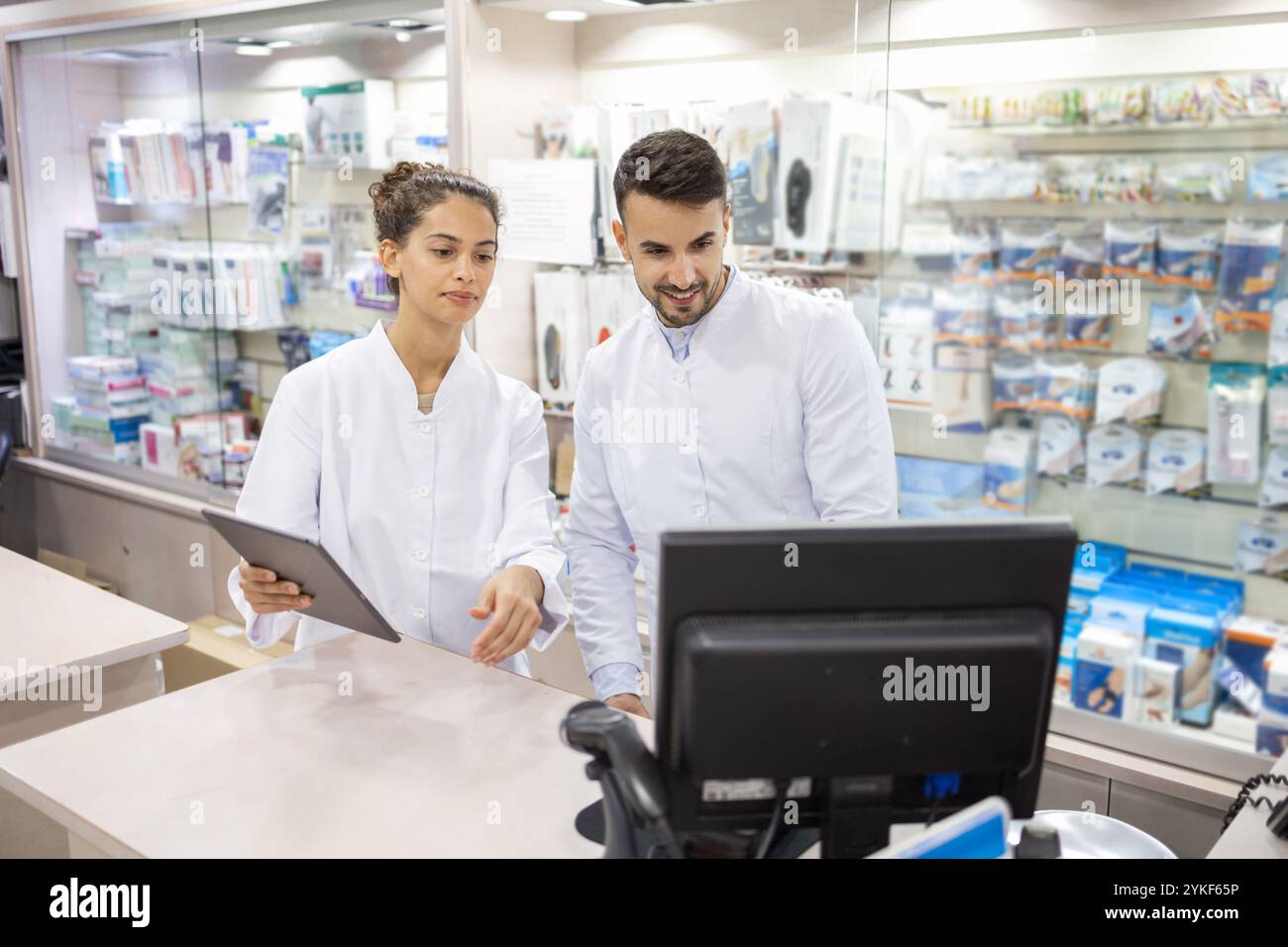 Due membri del personale professionale di un negozio di articoli di ortopedia assistono i clienti con scaffali specializzati per l'esposizione di vari prodotti ortopedici Foto Stock