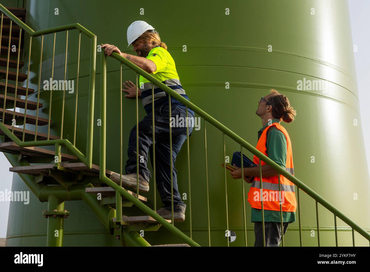 Un ispettore della sicurezza per disabili con problemi alle gambe monitora i rischi professionali in un sito di energia rinnovabile e sottolinea l'inclusione nella forza lavoro Foto Stock
