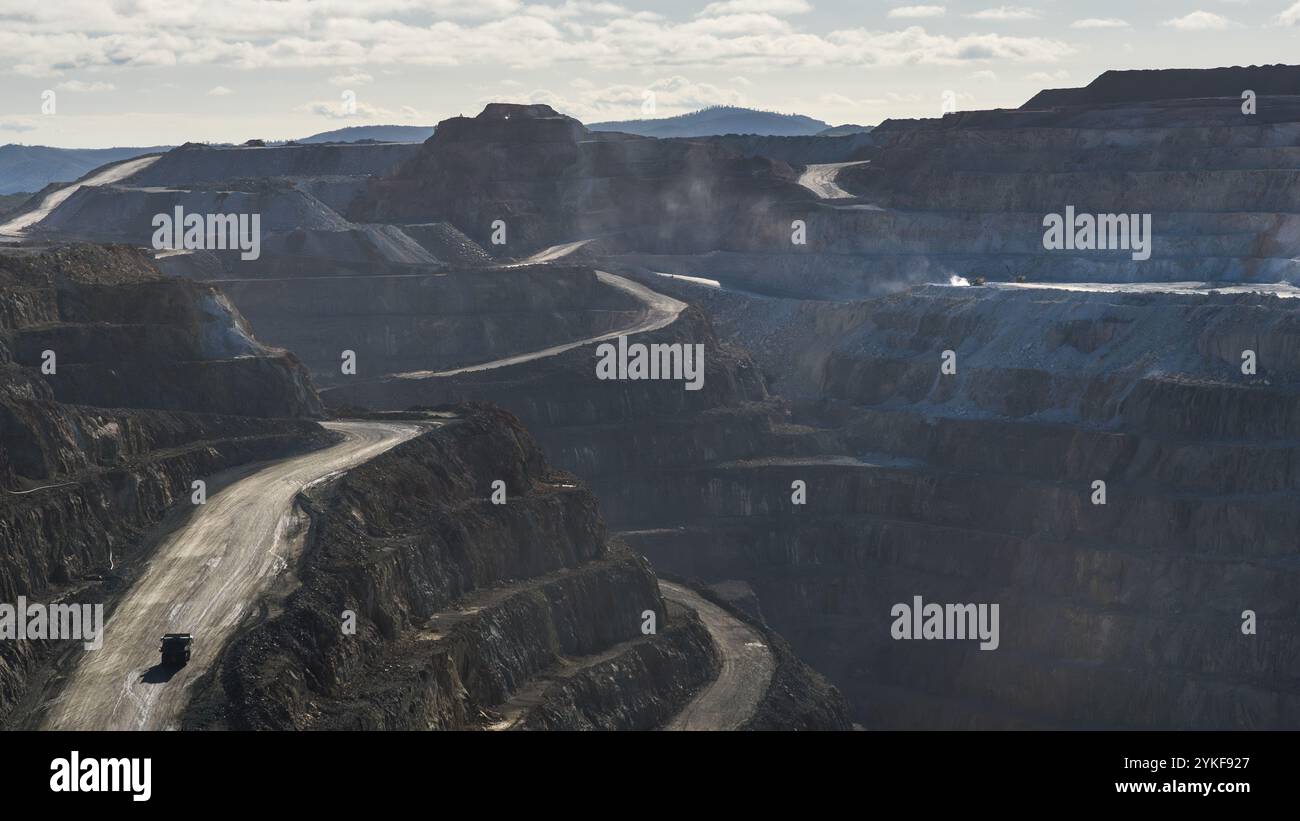Ripresa aerea che mostra la vasta miniera di Rio Tinto con le sue intricate terrazze e un camion solitario che naviga lungo le strade tortuose. Foto Stock