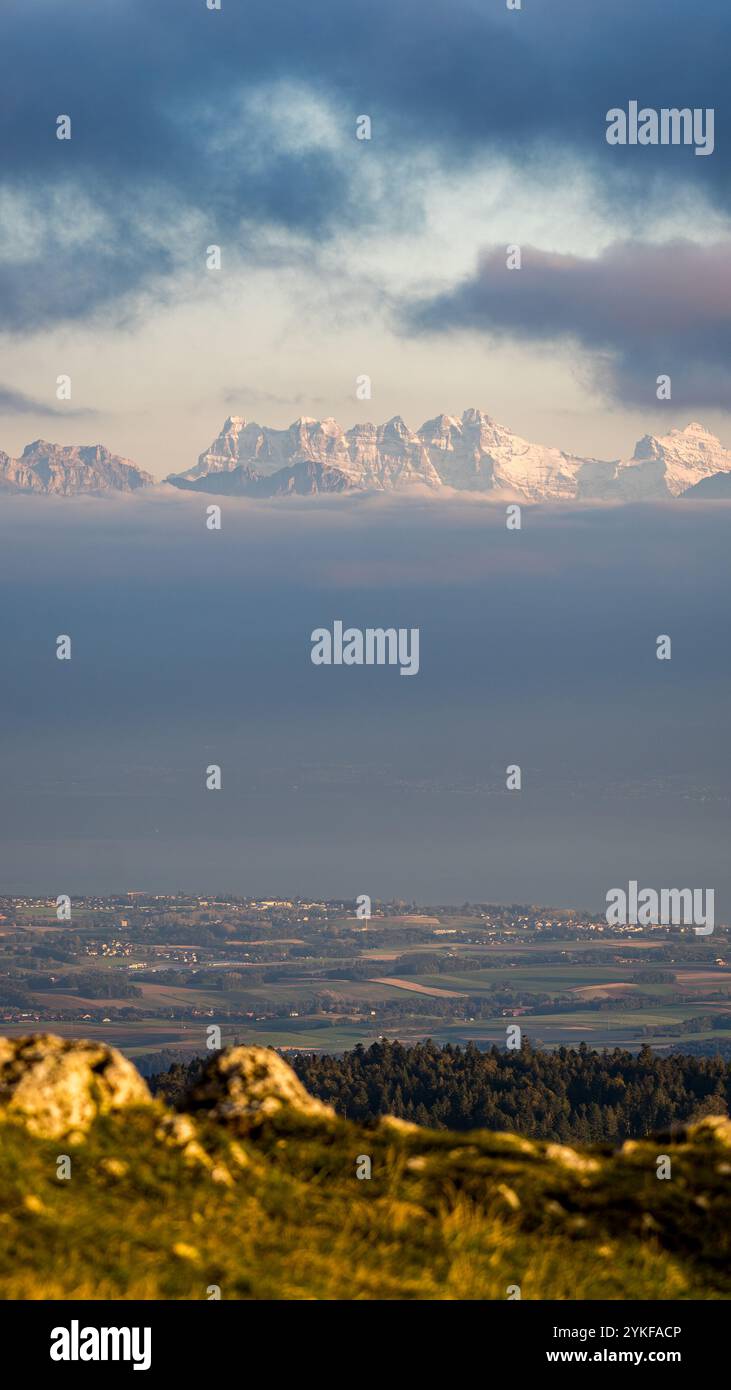 Una splendida vista delle cime innevate del Giura Svizzero durante un tramonto da Dent de Vaulion, che mostra strati di pittoresco paesaggio sotto dr Foto Stock