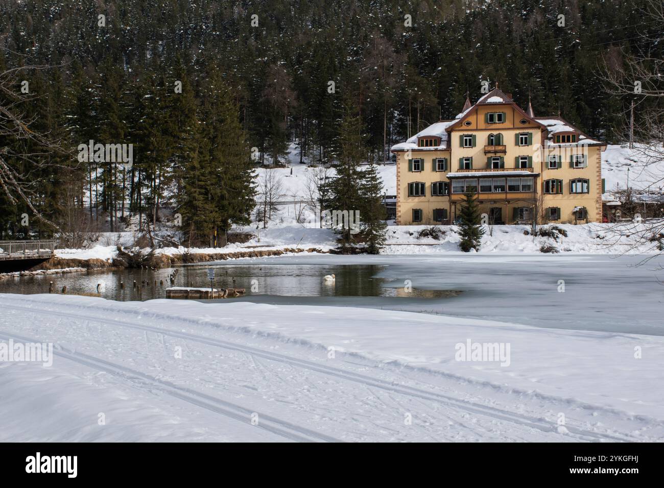 piccolo hotel coperto dalla neve invernale sulle rive del lago alpino si affaccia in attesa dell'arrivo dei turisti estivi Foto Stock