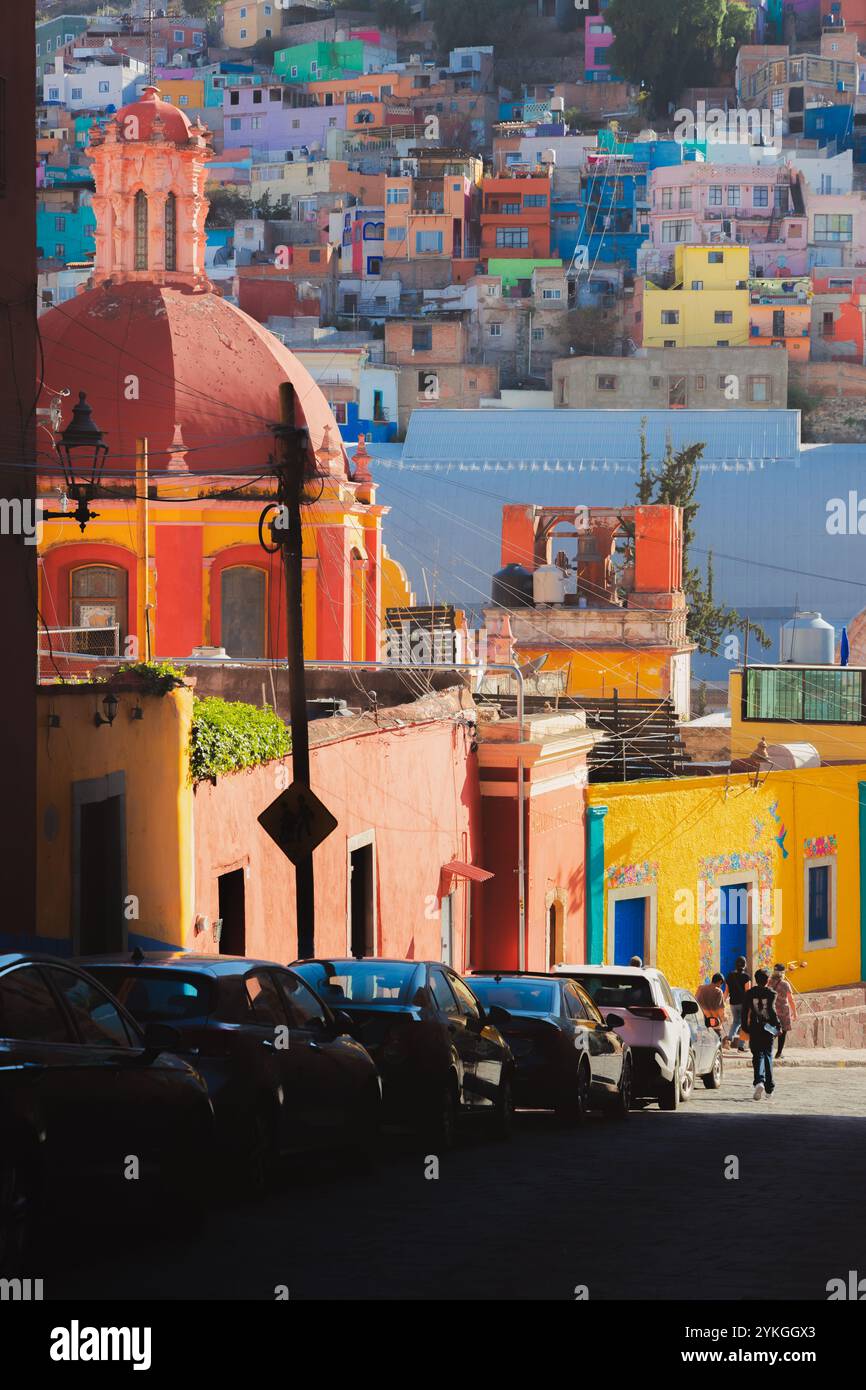 Una vibrante vista della storica cupola della basilica di Guanajuato e densamente ricche e colorate case sulle colline a Guanajuato, Messico, che mostrano un arco eclettico Foto Stock