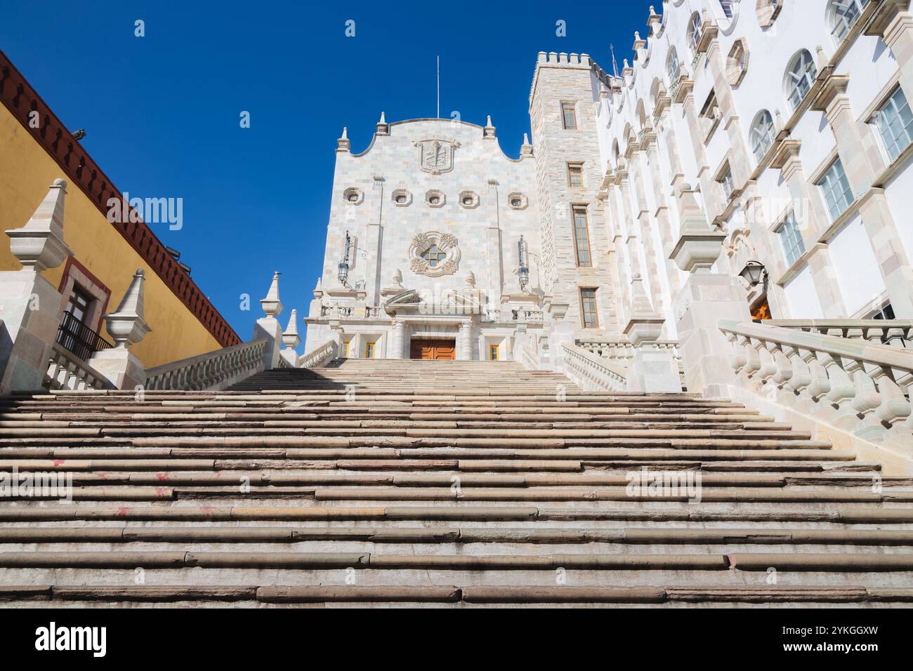 Il grande edificio barocco dell'Università di Guanajuato è caratterizzato da una scala decorativa in marmo bianco e si erge come un iconico histo Foto Stock