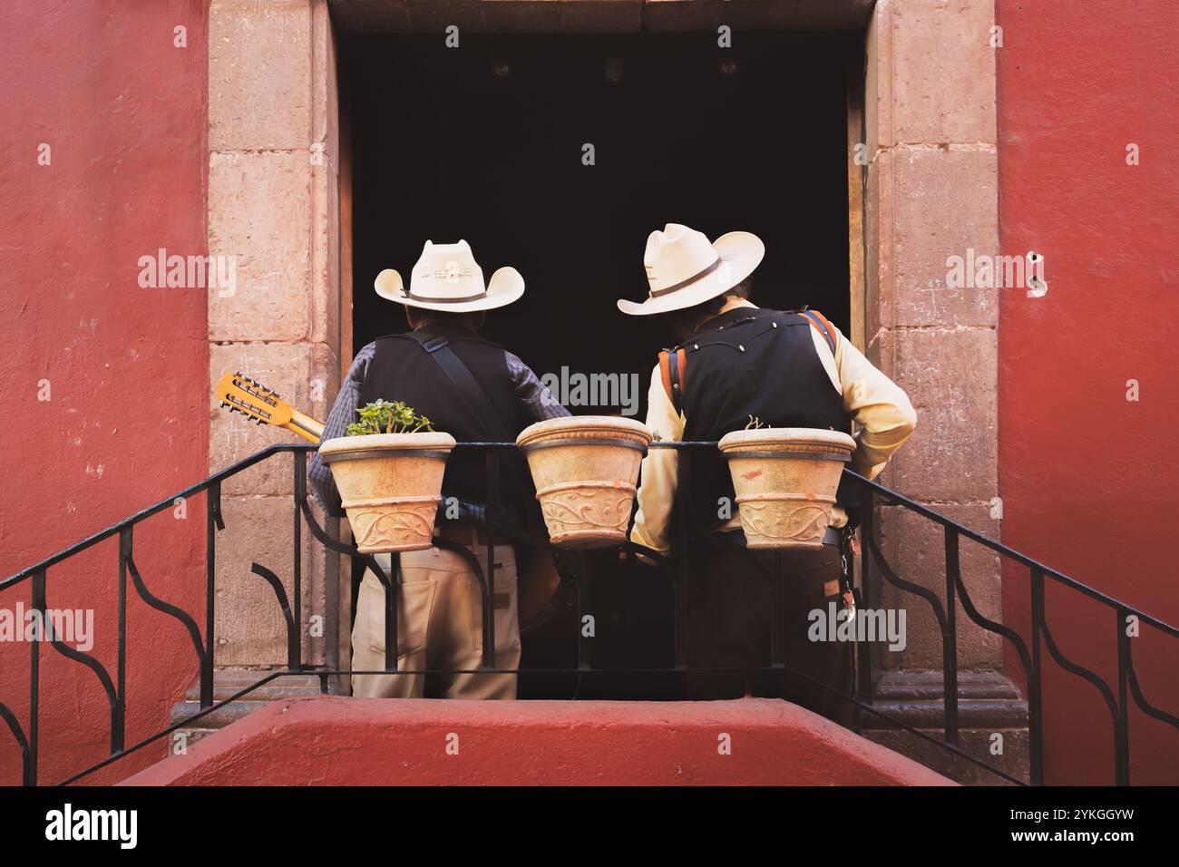 Guanajuato, Messico - 9 febbraio 2024: Due musicisti mariachi in cappelli da cowboy si preparano ad esibirsi su un balcone panoramico nella storica città vecchia di Guanajuato. Foto Stock