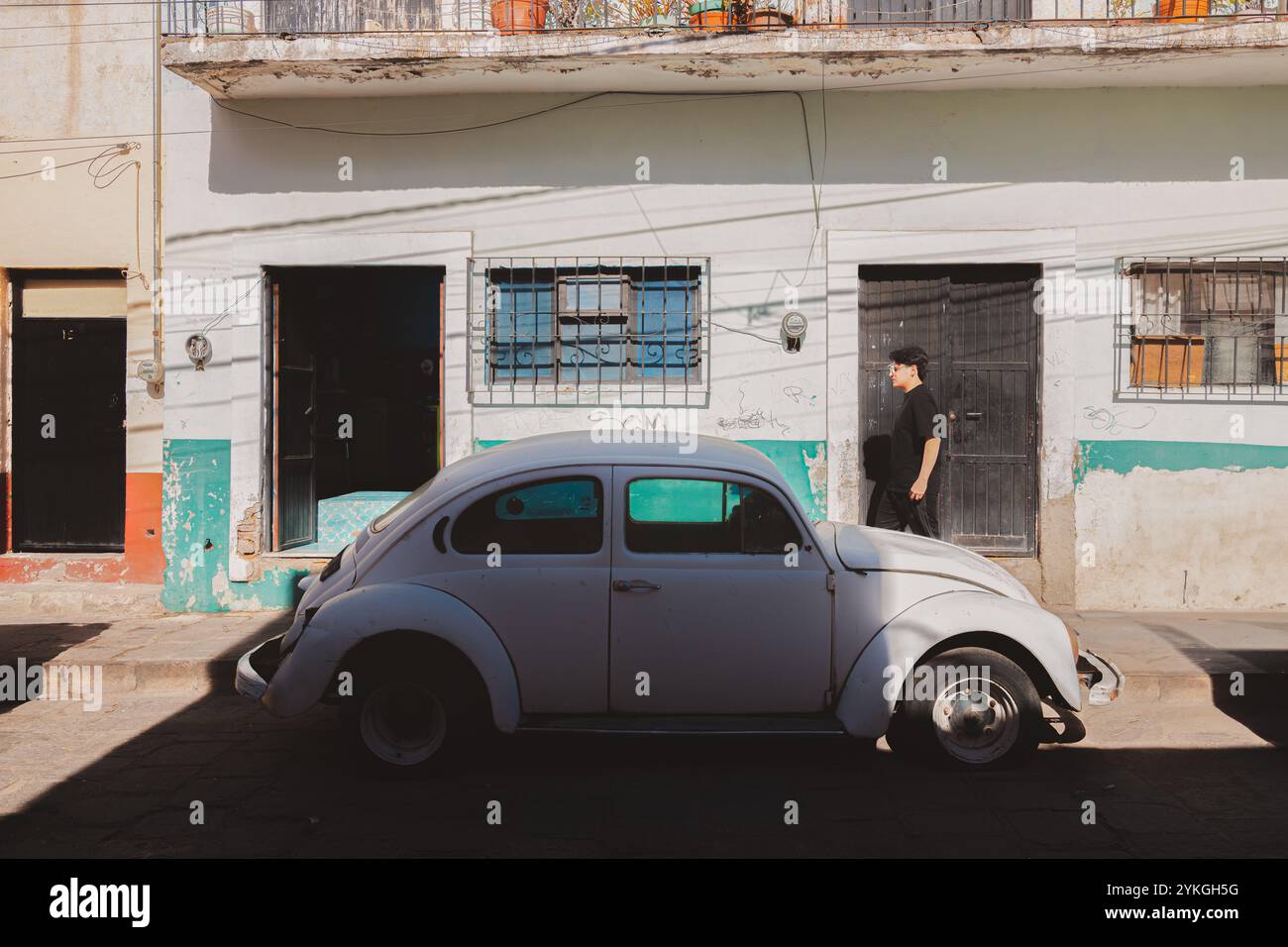 Guanajuato, Messico - 6 febbraio 2024: Uno scarabeo Volkswagen bianco d'epoca parcheggiato lungo una parete colorata e testurizzata a Guanajuato, Messico, che cattura il c Foto Stock