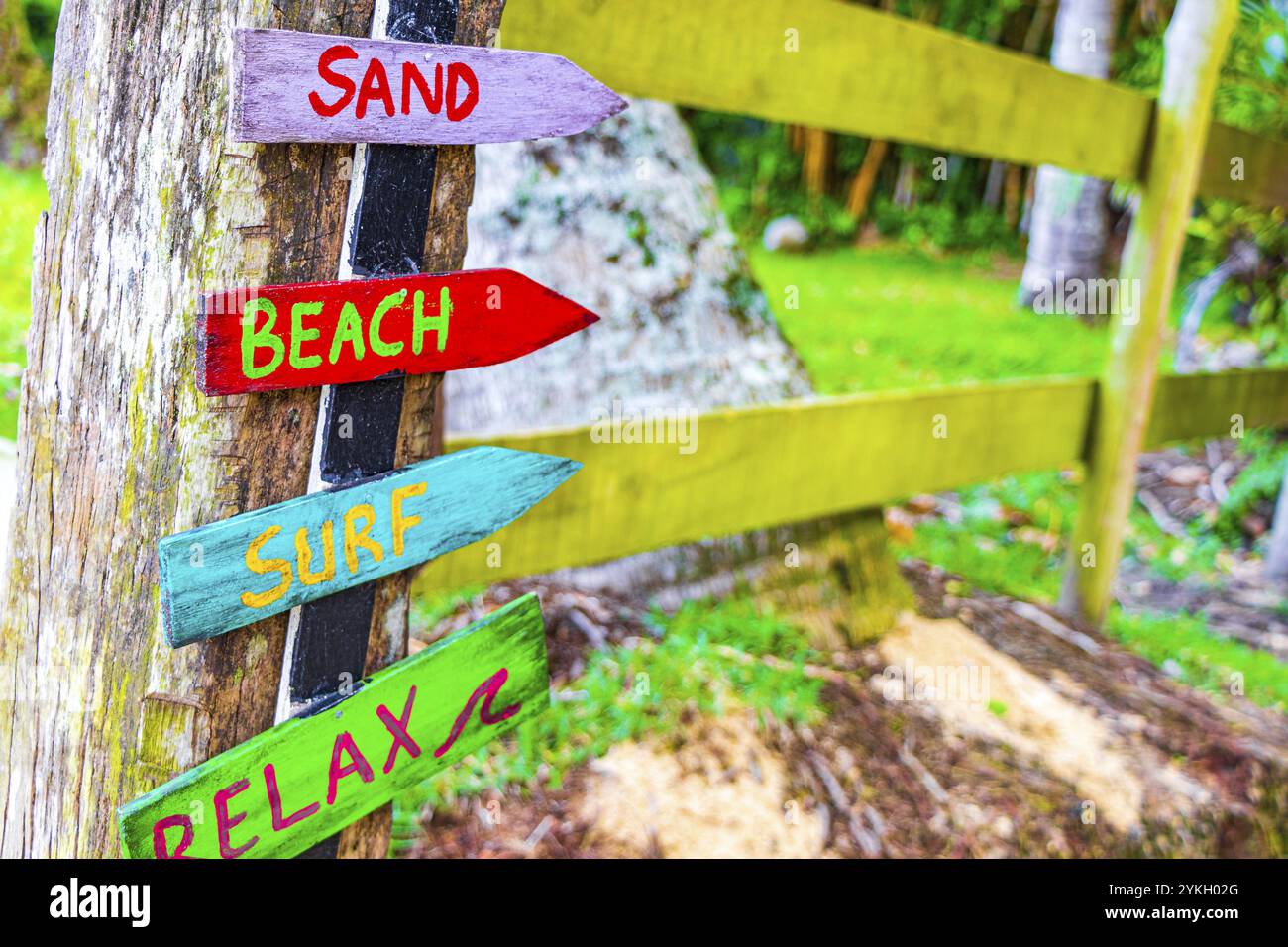 Spiaggia di sabbia surf e relax su colorate frecce di legno direzionale sulla spiaggia di Mangrove e Pooso spiaggia sull'isola tropicale Ilha Grande Rio de Janeiro Br Foto Stock