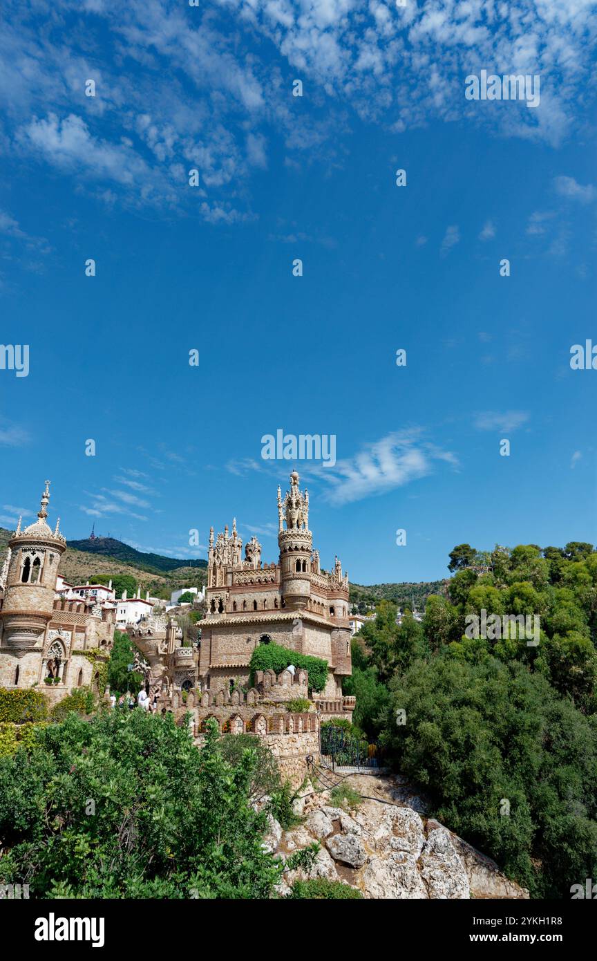 Il castello Colomares è circondato da una vegetazione lussureggiante, sotto un cielo azzurro Foto Stock